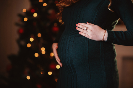 pregnant woman in a beautiful dress. Focus on the abdomen.の写真素材