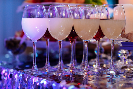 Glasses with wine. Many glass of wine on a table. Filled with half and stand on the holiday table. Furshet. selective focusの写真素材