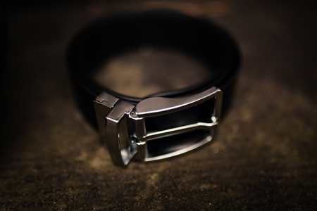 men's black uniform for pants. fashion leather belt on wooden background with steel metal buckle. black leather beltの写真素材