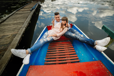 Top view of beautiful young couple taking selfie using smart phone while lying in the boat. Love Storyの写真素材