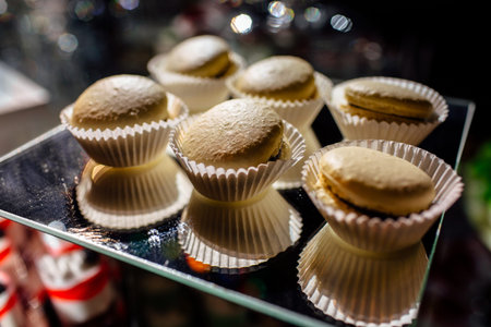 Chocolate macaroons cakes on a black background. Macaroons on black surface.