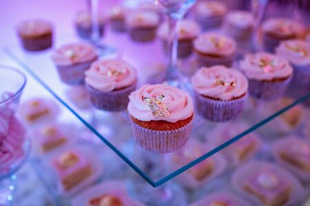 Set of different delicious tasty muffins on festive background. Different dessert tartlets with decorated cream. Selective focus. Candy bar conceptの写真素材