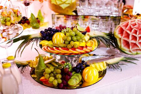 Fresh, exotic, organic fruits, light snacks in a plate on a buffet table. Assorted mini delicacies and snacks, restaurant food at event. Decorated delicious table for a party goodies.の写真素材