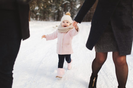 Happy family walking in the winter city park. Portrait of little cute daughter