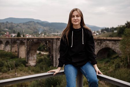 Woman tourist enjoys traveling to historical places in Ukraine, viaduct in the mountain resort village of Vorokhta, Carpathiansの写真素材