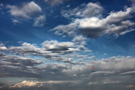skydiver in the sky. a lone parachute among beautiful clouds. Skydiver On Colorful Parachute In Sunny Sunset Sunrise Sky. Active Hobbies.の写真素材