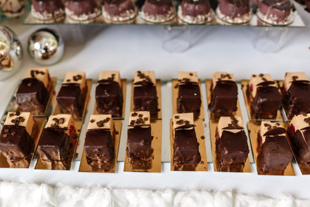 Table with sweets and goodies for the wedding party reception, decorated dessert table. Delicious sweets on candy buffet. Dessert table for a party. cakes, cupcakesの写真素材