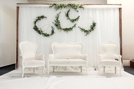 Beautiful decoration setup for wedding ceremony with classic white sofa and armchairs.の写真素材