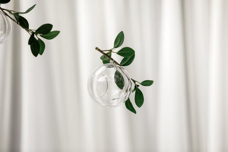 Original wedding floral decoration in the form of mini-vases and bouquets of flowers hanging from...