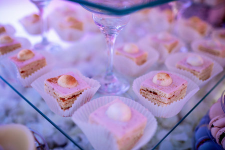 Candy bar on wedding ceremony with a lot of different cupcakes, modern desserts, mousses and...