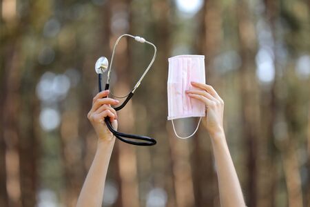 hands holding stethoscope and medical protective mask, isolated on natural background. concept love the environment. selective focus. copy space. medical careの写真素材