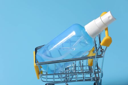 Clear hand sanitizer in a clear pump bottle isolated on a blue background. Hand sanitizer is used for killing germs, bacteria and viruses.の写真素材
