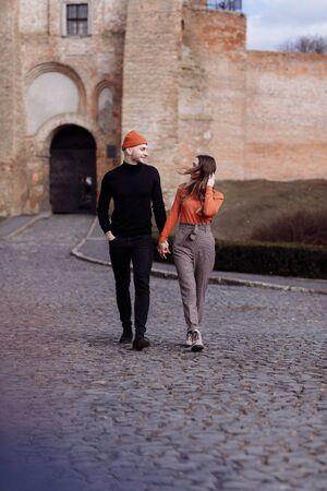 Love story of the beautiful young man and woman walking on the open air the city. embrace on a city walk. copy space. loving couple walking in the city in the open airの写真素材