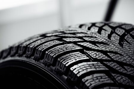 Stack of brand new high performance car tires on clean high-key white studio background. new car tire background. close up of textureの写真素材