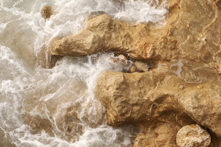 A close-up shot of the Mediterranean Sea turquoise water and powerful waves beating against the...