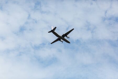 A beautiful view of a flying passenger wide-body airliner, an airplane, against a background of white clouds in a blue summer sky. selective focusの写真素材