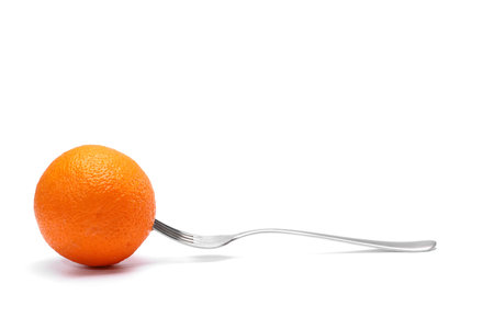 fresh orange fruit on a fork on white background. weight loss diet healthy food concept.の写真素材