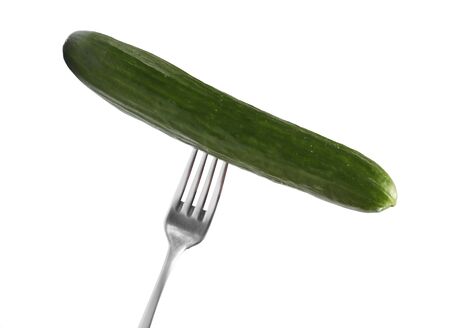 A fresh cucumber on a metal fork isolated on white background.の写真素材