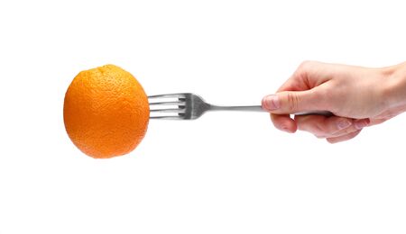 female hand holding orange fruit on fork isolated on White background. Healthy Lifestyle. selective focus. copy space.の写真素材