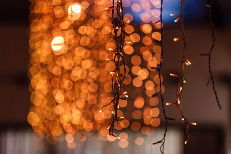 lights in a cafe window in the evening city and bright bokeh. Festive lyrical mood. selective focus.の写真素材