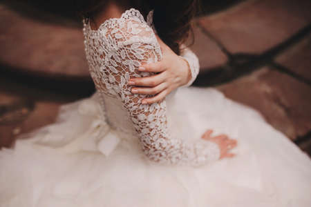 portrait of a beautiful young bride in a white wedding dress with long hair in the old European city. Woman near old building. wedding day.の写真素材
