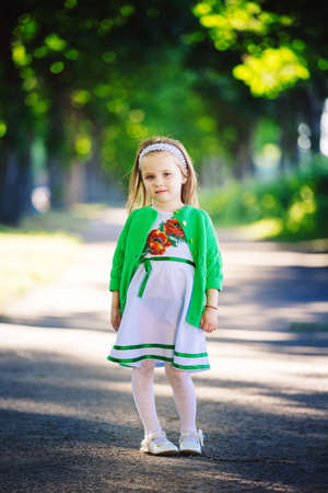 Cute little girl is having fun, jumping and laughing outdoors. happy childhood.の写真素材