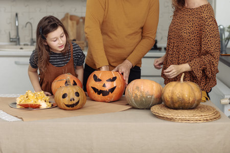 happy halloween. happy family mother father and daughter preparing for Halloween and having fun at home on the kitchen.
