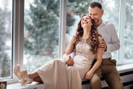 Photo shoot in the studio of a young married couple. A guy with a girl in festive clothes are celebrating Christmas. New Year's love story. The New Year Concept. valentine's day.の写真素材