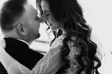 Young couple in love bride and groom posing in studio on background decorated with Christmas tree in...