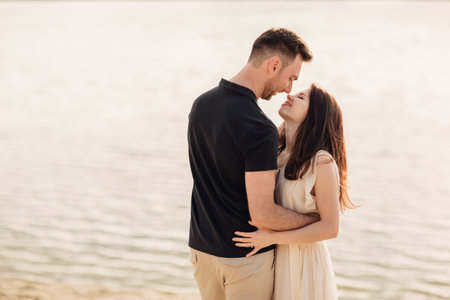 Beautiful couple having fun in sunflowers field. A man and a woman in love walk in a field with...