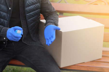 Delivery service courier during the Coronavirus, COVID-19, pandemic, cropped courier in medical...