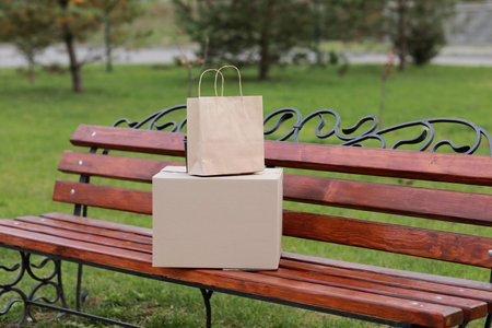 two parcels on a bench outdoors. Take-out concept. Online shopping. mock up. Service coronavirus.