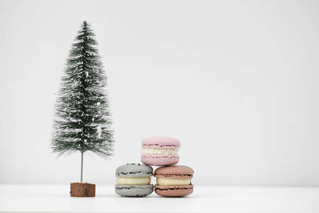 Macaroons or macarons and Christmas tree on a white background. Congratulations to the holidays. Minimalistic conceptの写真素材