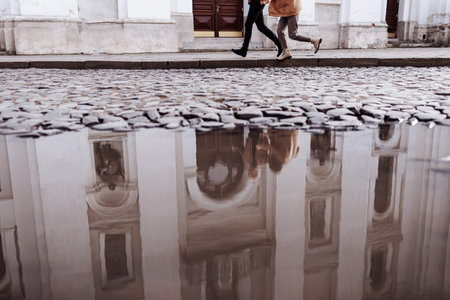 Cropped photo of a young loving couple running by street outdoors holding hands of each other