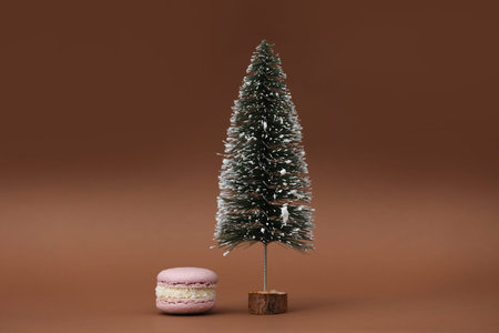 Macaroon or macaron and Christmas tree on a brown background. Congratulations to the holidays....