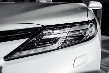 headlight of modern prestigious white car close up. Close up photo of modern car, detail of...