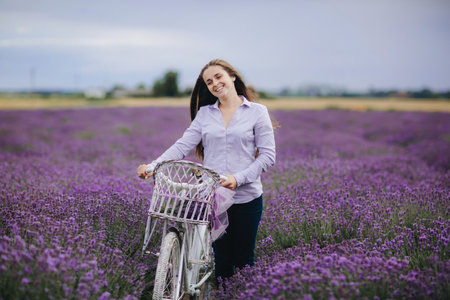 beautiful young Woman with retro bicycle in lavender field. happy girl outdoorsの写真素材