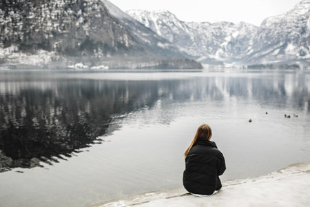 young female freelancer working on laptop in the mountains in the evening. Tourist girl sitting near...
