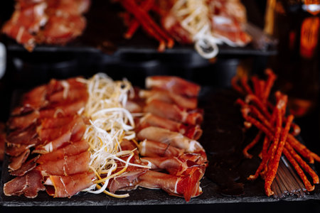 Antipasto platter cold meat, prosciutto, slices ham, beef jerky, salami and cheese platter on gray background. Closeup of beer snacks set.の写真素材