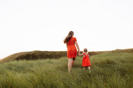 black and white photo. Portrait of a mother is having fun with daughter on nature on summer day vacation. Mom and girl playing in the park at the sunset time. Concept of friendly familyの写真素材