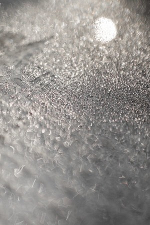 Ice and frost background on frozen glass. Colored in silver or gray tone. Selective focus at center...