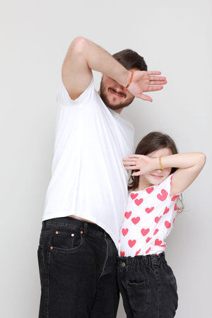 young dad holds his little daughter in his hands. father hugging his child with love and child kiss...