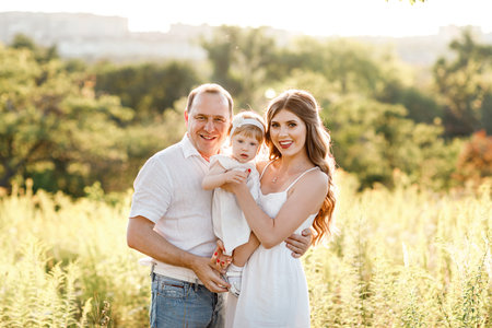 Family enjoying life together in the summer park. People having fun in nature. Happy young family...