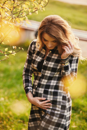 pregnant woman in long white dress touching her belly in decoration studio with stars, moon....