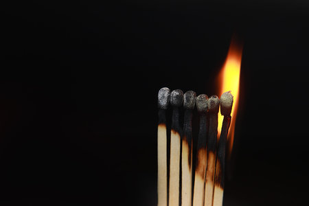 Burning matches on black background. matchsticks on fire in row of burning is sequence while one...