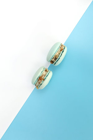 Tasty blue french macarons or macaroons on a white and blue background. Place for text. color...