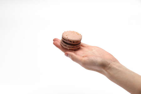 hand holding sweet and colorful french chocolate macaroons or macaron isolated on white backgroundの写真素材