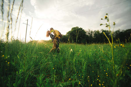 A man and a woman are hitchhiking. A young couple goes hitchhiking around the country. Free hitchhiking trip. A lover who travels free by hitchhiking. The couple goes traveling. Couple by the road.の写真素材
