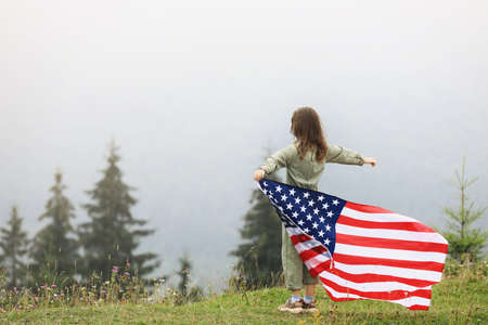 Happy laughing little girl flying a colorful kite, running and jumping on foggy day in the mountains during active family vacation. Kids playing outdoors. happy childhood.の写真素材