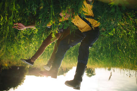The bride and groom go through the forest hand in hand. Happy bride and groom holding hands and walking in forest on wedding dayの写真素材